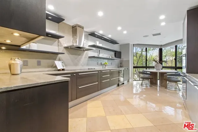 a kitchen with stainless steel appliances granite countertop a sink counter space and chairs in it