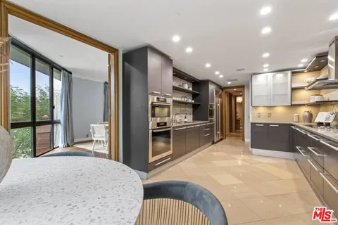 a kitchen with stainless steel appliances kitchen island granite countertop a refrigerator and a sink