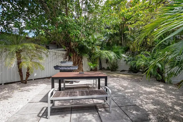 a view of backyard with a table and chair and wooden fence