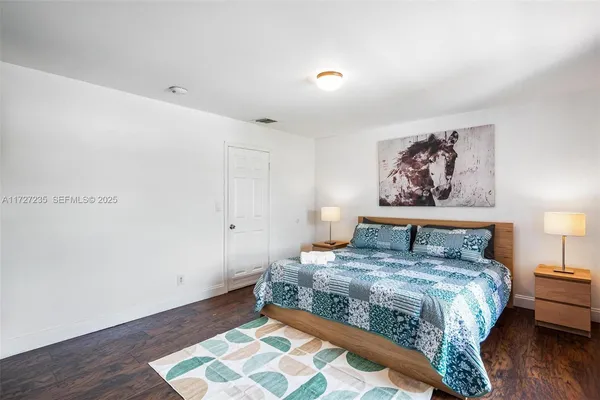 a bedroom with a bed and a painting on the wall