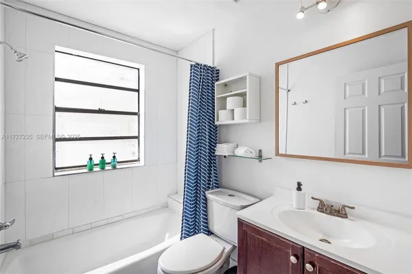 a bathroom with a sink toilet vanity and tub