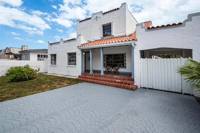 a view of a house with backyard and a tree