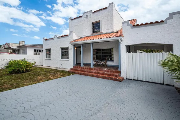 a view of a house with backyard and a tree