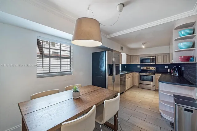 a kitchen with stainless steel appliances kitchen island granite countertop a stove a sink a refrigerator and chairs