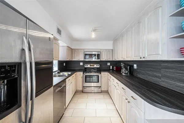 a kitchen with stainless steel appliances granite countertop a refrigerator and a sink