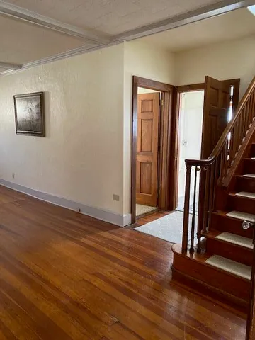 a view of an entryway with wooden floor and door