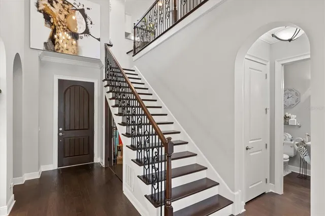 a view of a hallway with wooden floor and staircase