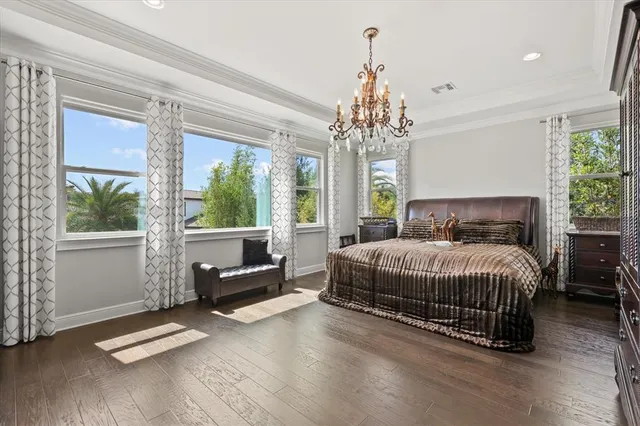 a spacious bedroom with a bed and a chandelier