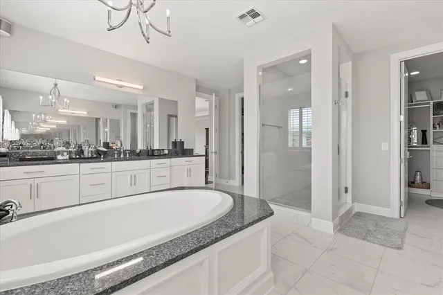 a spacious bathroom with a granite countertop sink mirror and shower