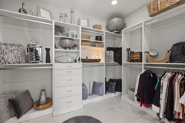 a view of walk in closet with clothes and shoes