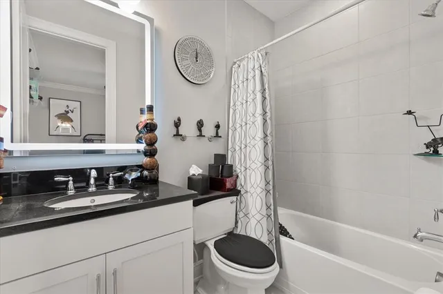 a bathroom with a granite countertop sink a toilet and a bathtub