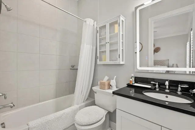 a bathroom with a granite countertop sink toilet a mirror and shower