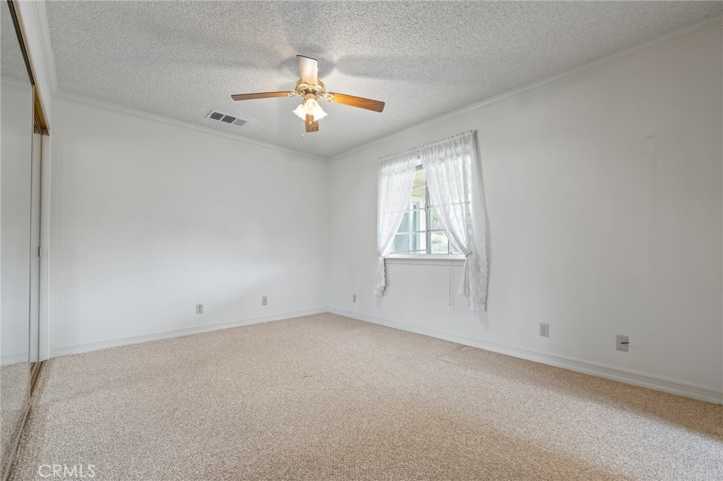 57622 Sierra Way Yucca Valley, CA 92284 - Photo 21 of 55 an empty room with chandelier fan and windows