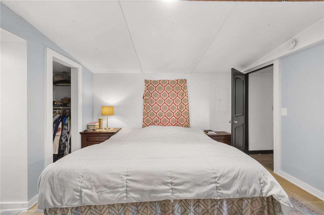 217 Old River Road Pelzer, SC 29669 - Photo 13 of 30 This serene sleeping area offers convenient walk-in access to a personal wardrobe space and features a distinct decorative wall hanging.