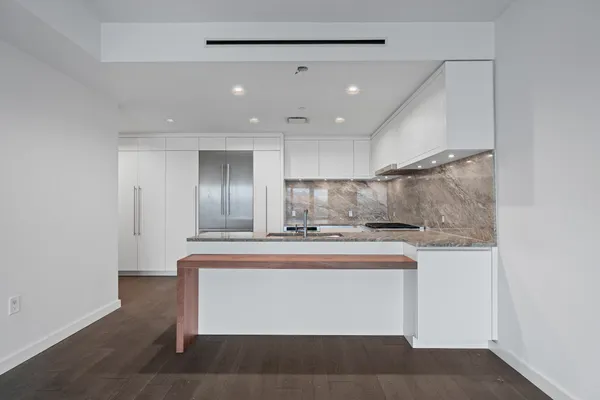a view of kitchen with stainless steel appliances granite countertop cabinets and wooden floor