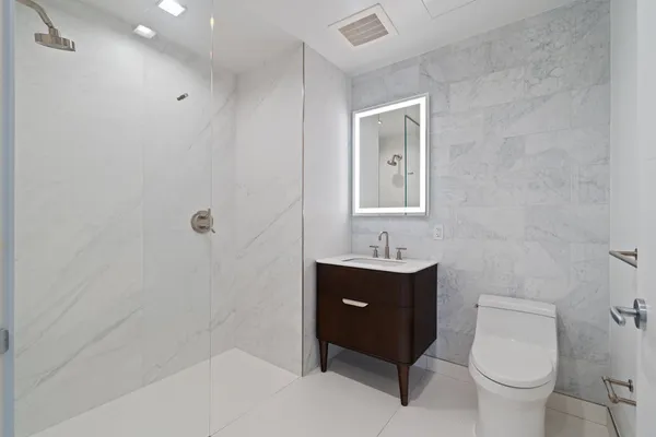 a bathroom with a toilet sink vanity and mirror
