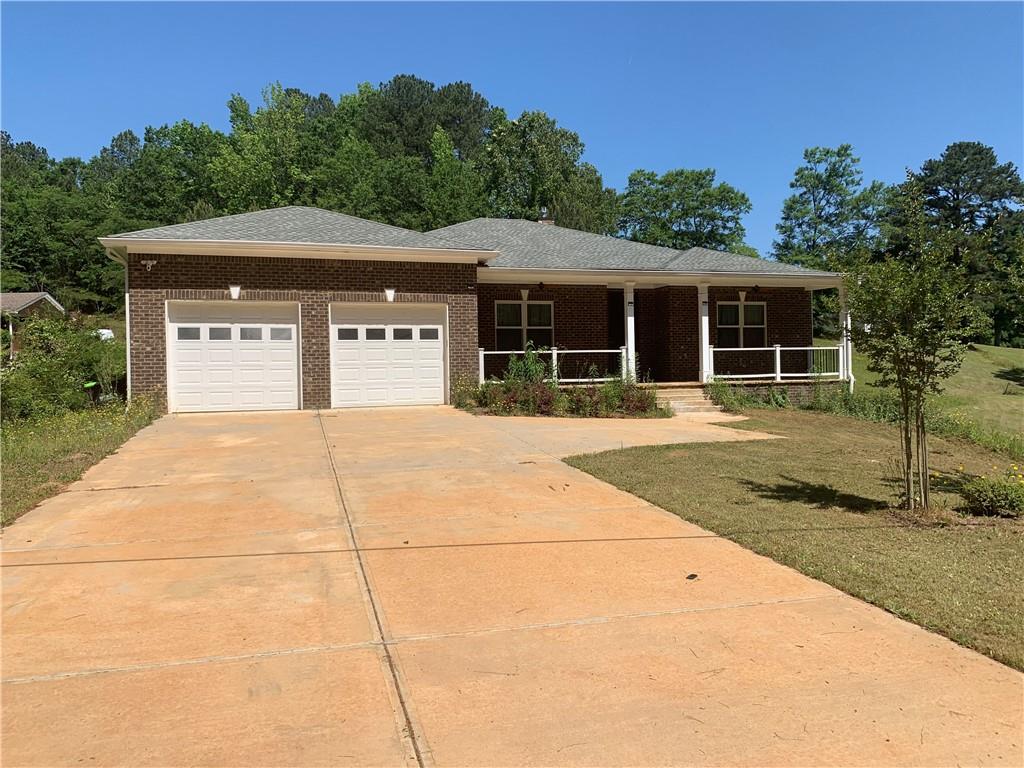 6816 Queen Mill Road Southeast Mableton, GA 30126 - Photo 1 of 1 a front view of house with yard and trees in the background
