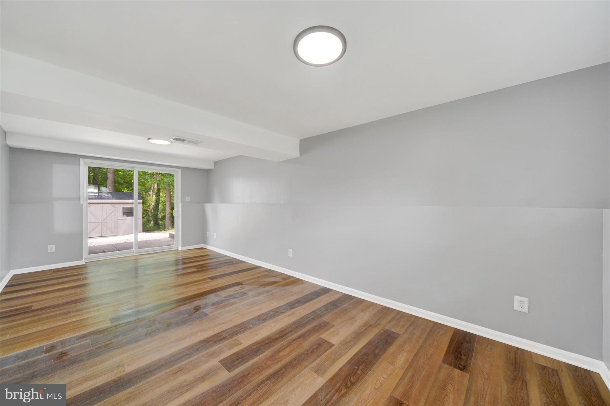 220 Sandhill Road Baltimore, MD 21221 - Photo 23 of 30 a view of empty room with wooden floor and fan