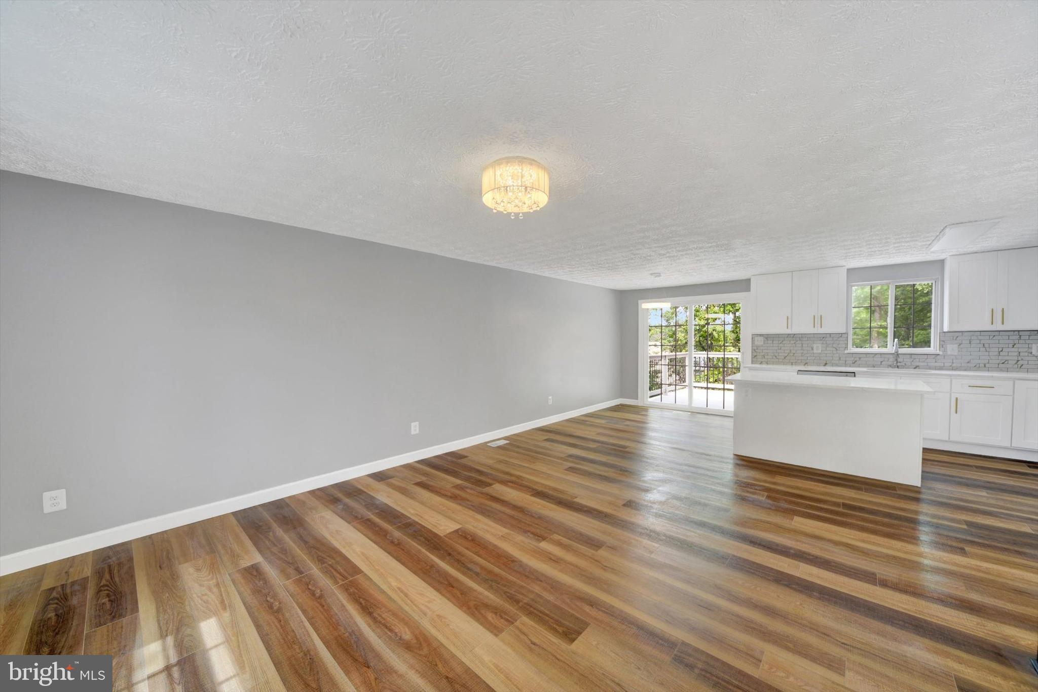 220 Sandhill Road Baltimore, MD 21221 - Photo 5 of 30 a view of empty room with wooden floor and fan