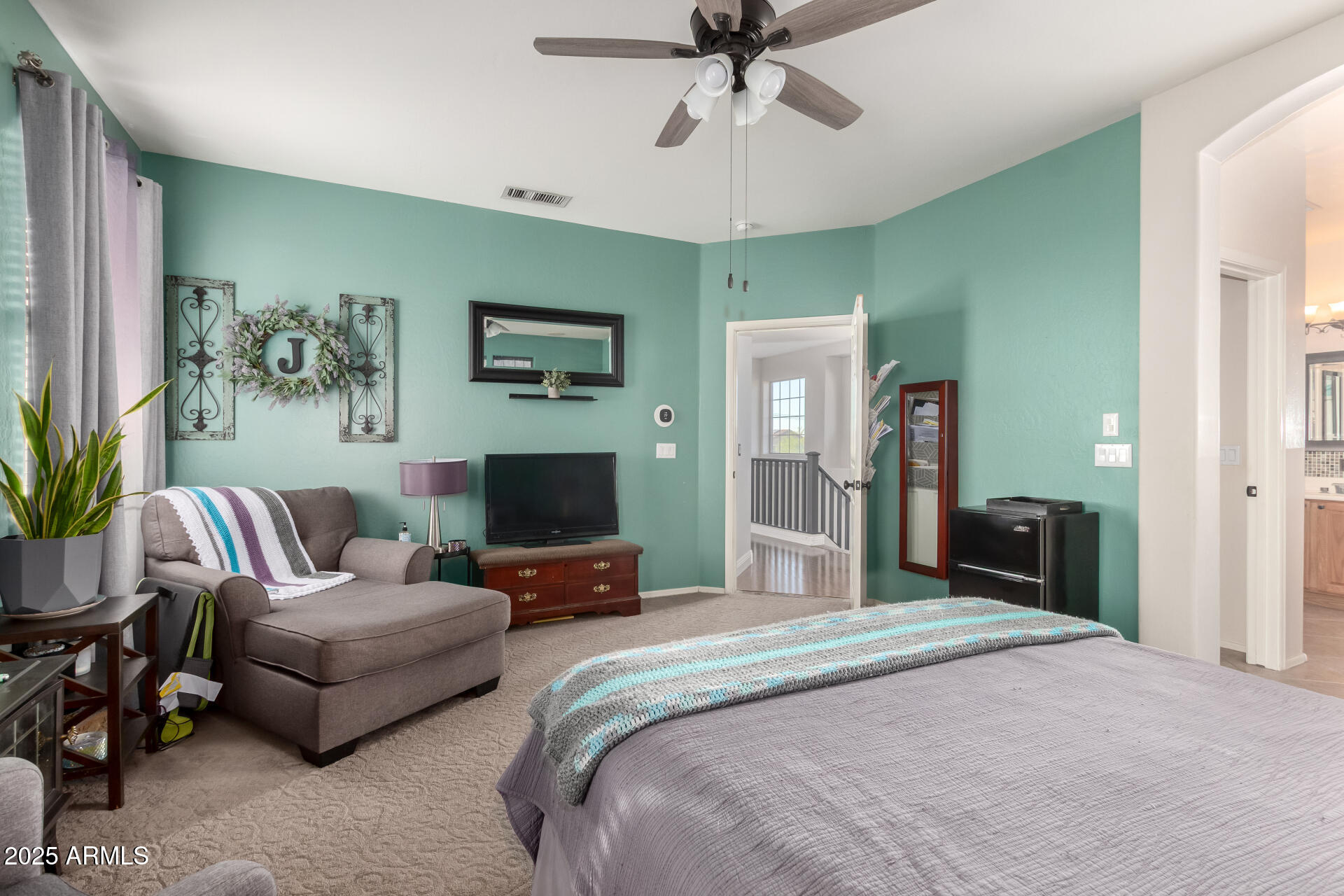 17441 West Arroyo Way Goodyear, AZ 85338 - Photo 17 of 27 a spacious bedroom with a bed a couch and a chandelier