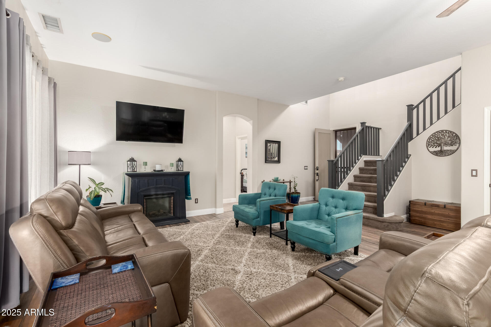 17441 West Arroyo Way Goodyear, AZ 85338 - Photo 5 of 27 a living room with furniture a flat screen tv and a fireplace