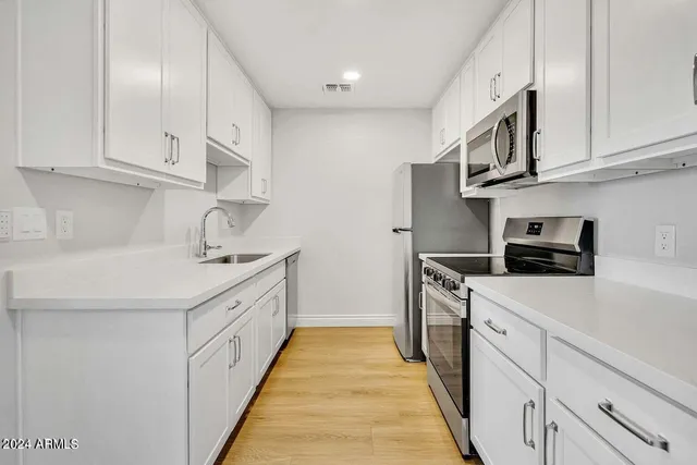 a kitchen with cabinets and stainless steel appliances