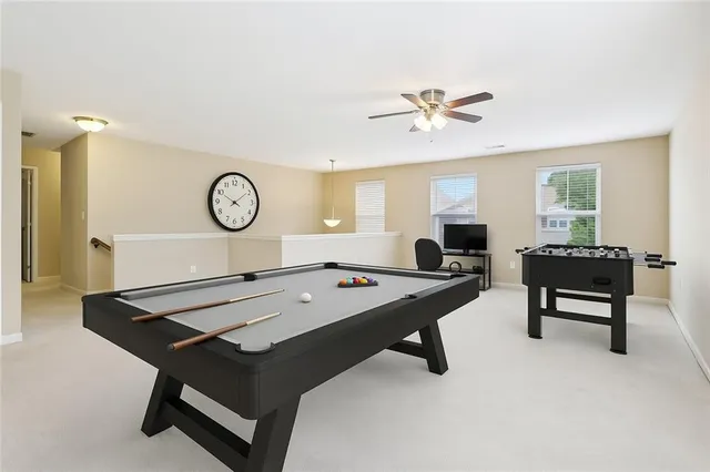 a room with furniture pool table and window
