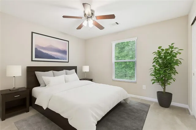 a bedroom with a large bed and a potted plant