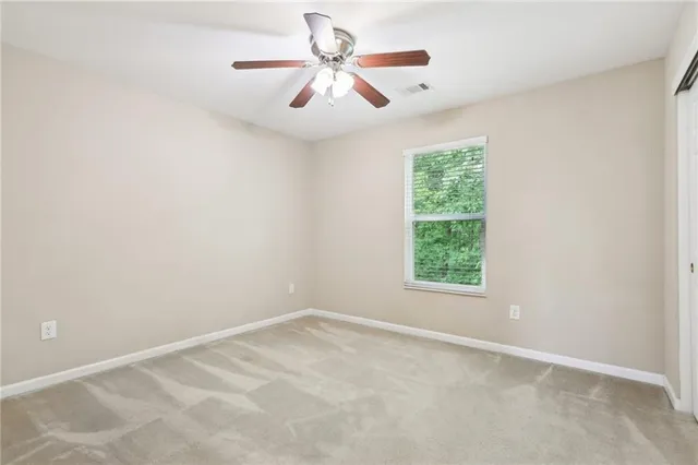an empty room with a window and a fan