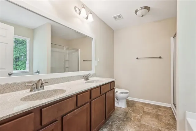 a bathroom with a granite countertop sink a toilet and a mirror