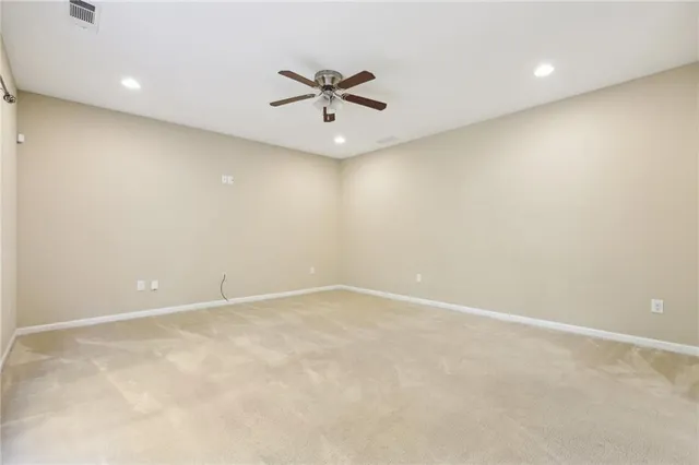 an empty room with a ceiling fan and window