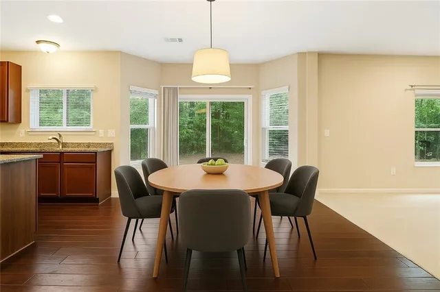 a dining room with furniture a chandelier and wooden floor