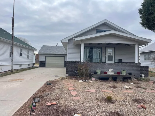 a front view of a house with cars parked