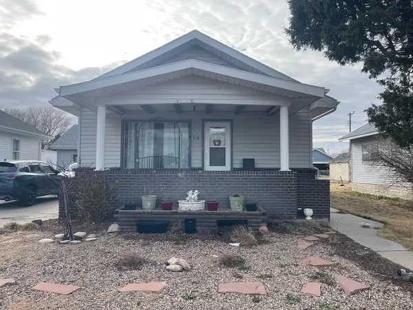 a front view of a house with a yard covered in snow