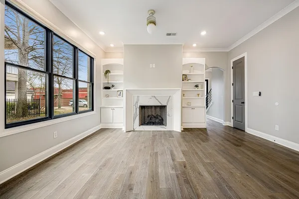a view of an empty room with a fireplace and a window