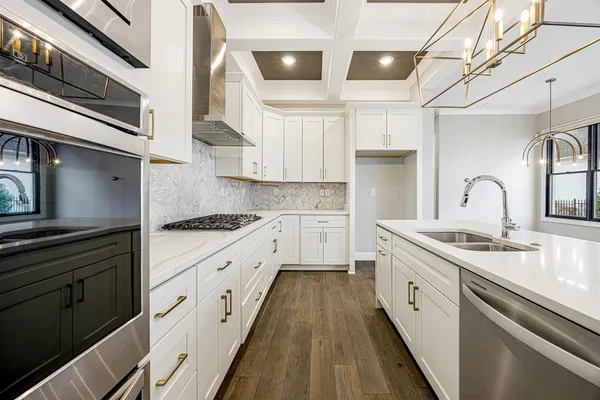 a kitchen with kitchen island white cabinets and stainless steel appliances