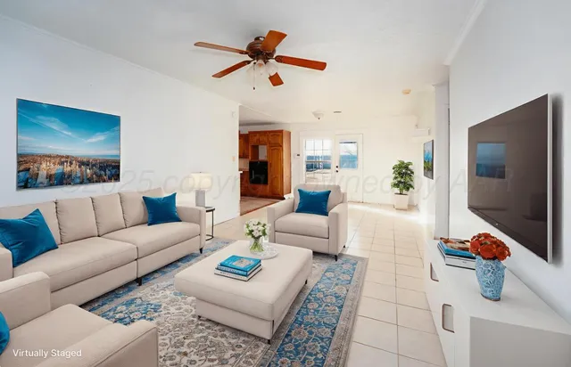 a view of a livingroom with wooden floor and a ceiling fan