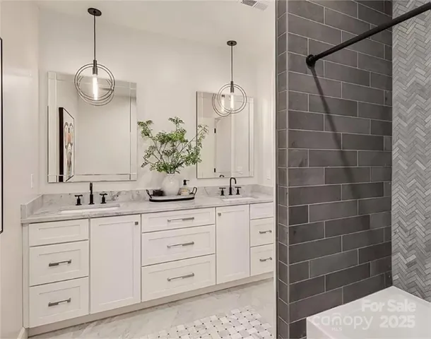 a bathroom with a double vanity sink a mirror and a shower