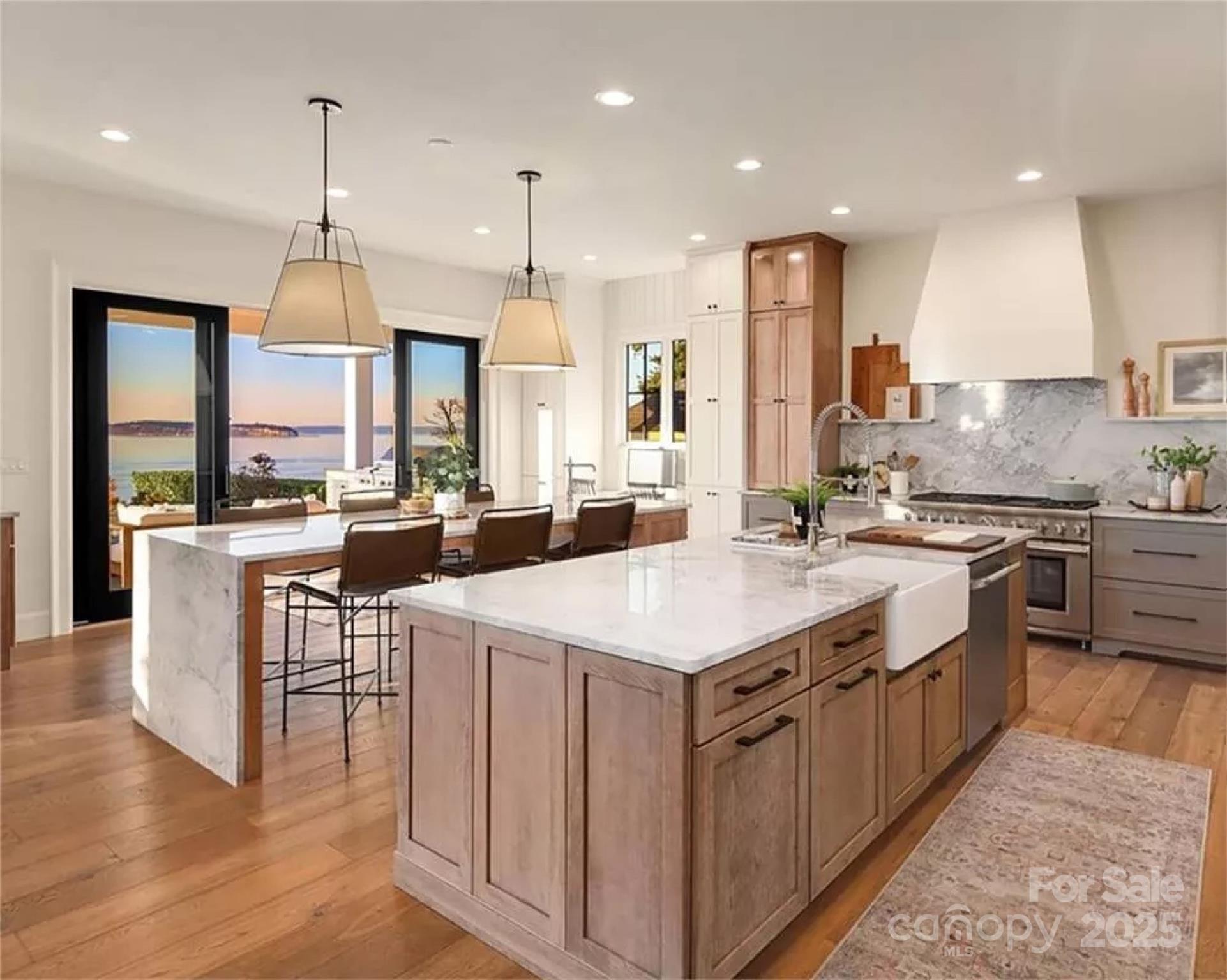 9490 Sherrills Ford Road Terrell, NC 28682 - Photo 21 of 24 a large kitchen with kitchen island a stove a sink a center island and a wooden floor