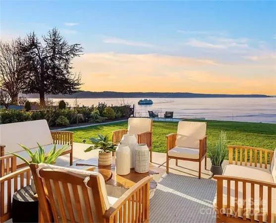 a view of a patio with couches potted plants and ocean view