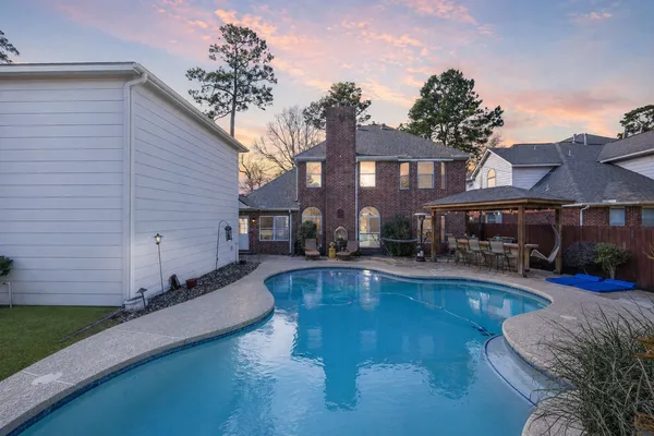 a swimming pool view with a seating space and a garden view