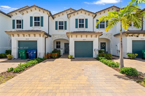 a front view of a house with a yard and garage