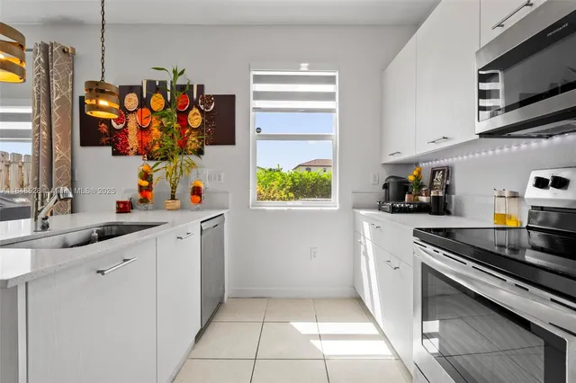 a kitchen with stainless steel appliances kitchen island granite countertop a sink and a stove