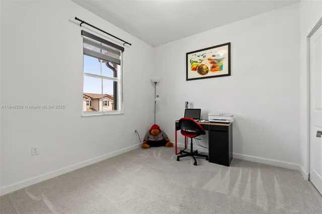 a view of a workspace with furniture and window