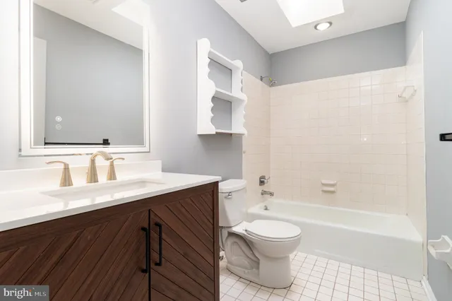 a bathroom with a granite countertop sink toilet a large mirror a bathtub and shower