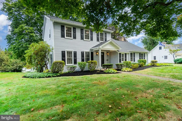 a front view of a house with a yard and trees