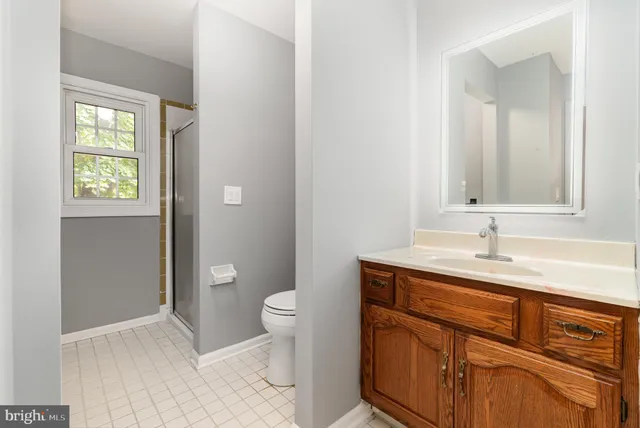 a bathroom with a granite countertop toilet sink and mirror