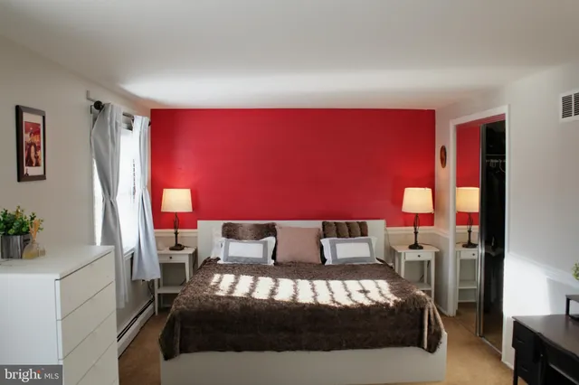 a bedroom with a large bed and a potted plant