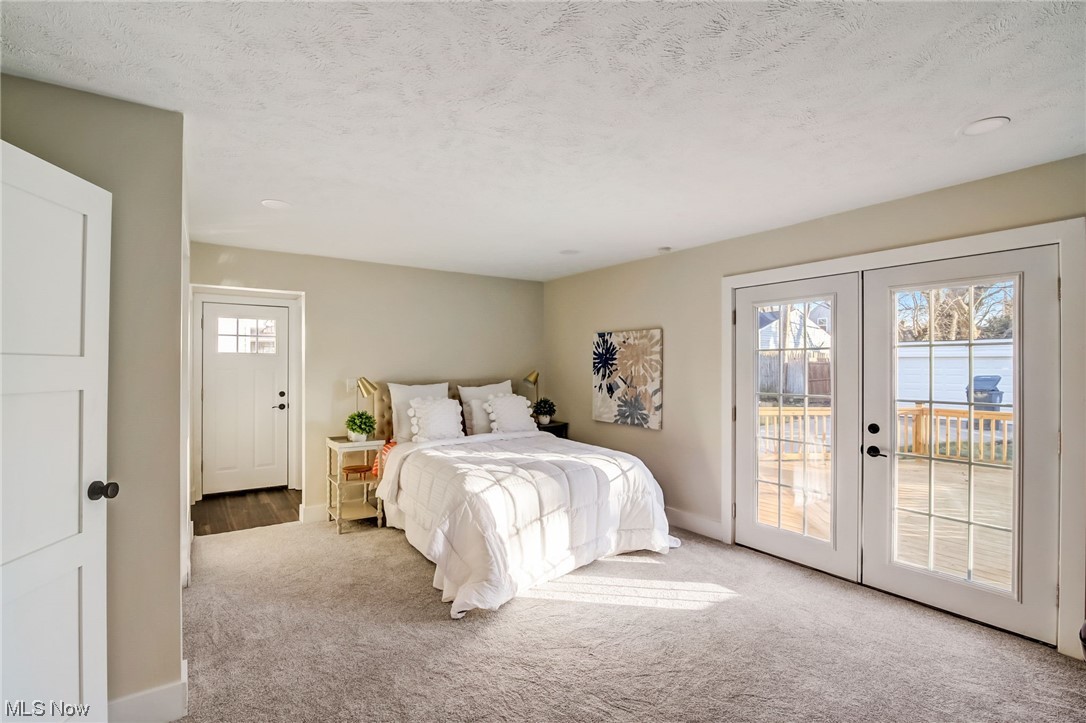 3660 Harvey Road Cleveland, OH 44118 - Photo 10 of 32 Carpeted bedroom featuring access to outside, a textured ceiling, multiple windows, and french doors