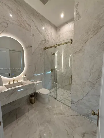a bathroom with a sink mirror vanity and toilet